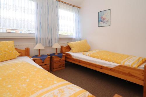 - une chambre avec 2 lits et une fenêtre dans l'établissement Janssen Ferienwohnungen, à Leybuchtpolder