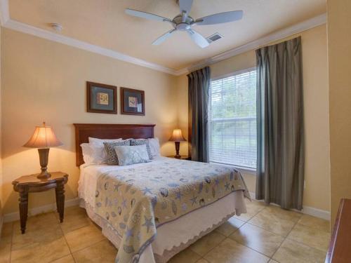 a bedroom with a bed with a ceiling fan and a window at Disney Memories at Tuscana Resort in Kissimmee