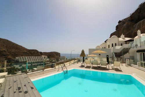 een zwembad met uitzicht op de oceaan bij Calypso Boutique Apartments in Puerto Rico de Gran Canaria