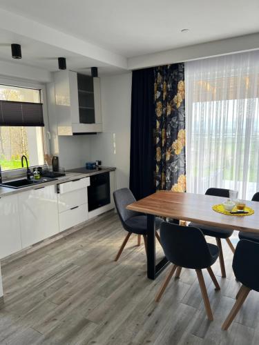 a kitchen and dining room with a table and chairs at Domek nad Doliną Dunajca in Zakliczyn