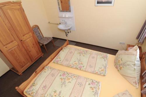 Cette chambre comprend 2 lits et un lavabo. dans l'établissement Janssen Ferienwohnungen, à Leybuchtpolder