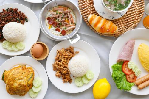 a table with plates of food on it at AU Place Hotel in Loei