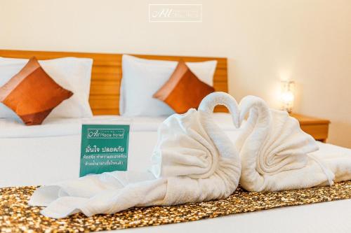two swans towels sitting on top of a bed at AU Place Hotel in Loei