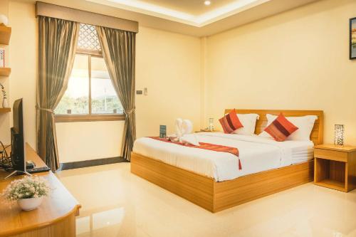 a bedroom with a bed and a desk and a television at AU Place Hotel in Loei