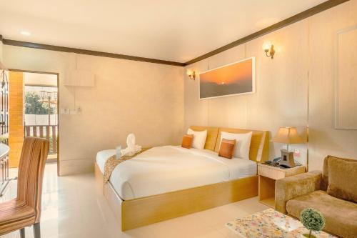 a bedroom with a bed and a couch and a chair at AU Place Hotel in Loei