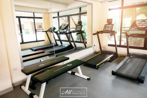 a gym with treadmills and ellipticals in a room at AU Place Hotel in Loei