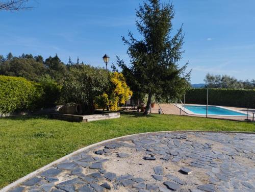 un cortile con piscina, albero e prato di Cal Espardanyer a Girona