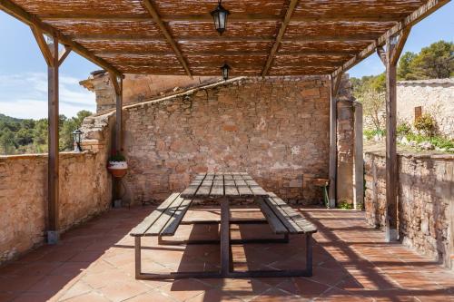 a picnic table on a patio with a brick wall at El Mas in San Martín de Tous