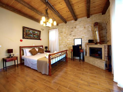 een slaapkamer met een bed en een open haard bij Diamond Villas in Gavalochori