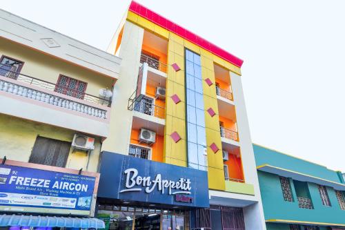 un edificio colorido con un cartel delante en Sri Abirami Inn, en Pondicherry