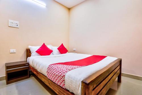 1 dormitorio con 1 cama grande con almohadas rojas en Sri Abirami Inn, en Pondicherry