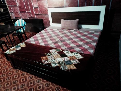 a bed with a checkered blanket on top of it at OYO Mayur Guest House in Jīnd