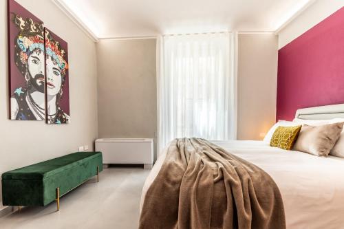 a bedroom with a large bed with a green bench at Ortigia's Queen in Siracusa