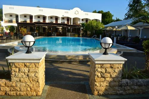 a swimming pool with two lights on two stone pillars at Panglao Regents Park Resort in Panglao