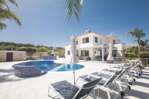 a villa with a swimming pool and lounge chairs at Villa Margarita in Protaras
