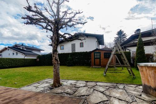 a tree in a yard next to a house at Chalet Hohe Tauern - Steinbock Lodges in Zell am See