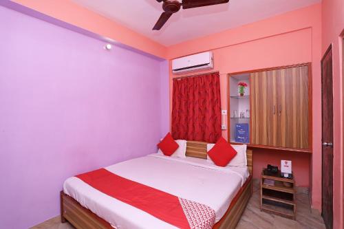 a bedroom with a bed with red pillows at OYO Silver Inn Near Acropolis Mall in Jādabpur