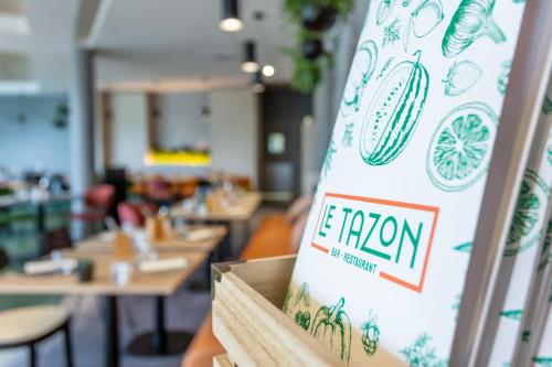 a sign in a restaurant with tables and chairs at Novotel Bourges in Bourges