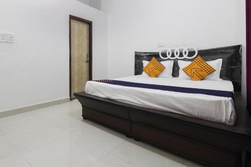 a bedroom with a bed with yellow and blue pillows at SPOT ON Green Valley in Meerut