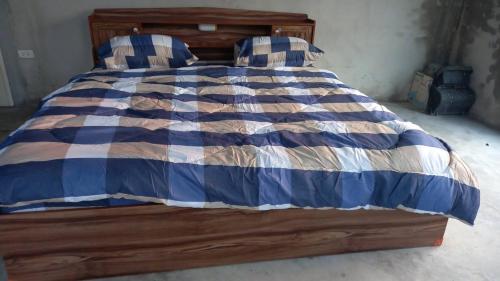 a bed with a blue and white blanket and pillows at Starry Night hostel in Ban Mae Chong