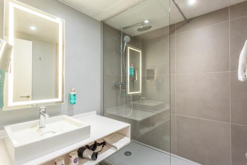 a bathroom with a sink and a shower at Novotel Bourges in Bourges
