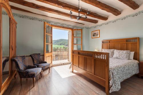 1 dormitorio con 1 cama, 1 silla y 1 ventana en El Mas de Tous, en Sant Martí de Tous
