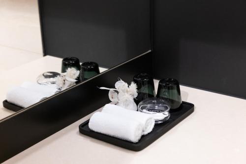 einen Spiegel mit Handtüchern und Gläsern im Bad in der Unterkunft HOtello Lehel in München