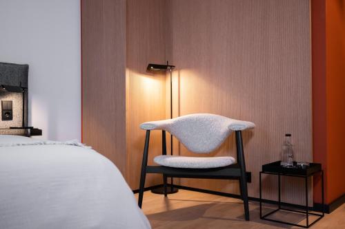 a chair sitting in a room next to a bed at HOtello Lehel in Munich