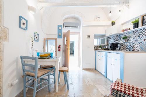 a kitchen with blue and white cabinets and a table and chairs at Vico di Ostuni Apartments by Rentbeat in Ostuni