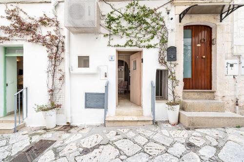 a white house with stairs and a door at Vico di Ostuni Apartments by Rentbeat in Ostuni