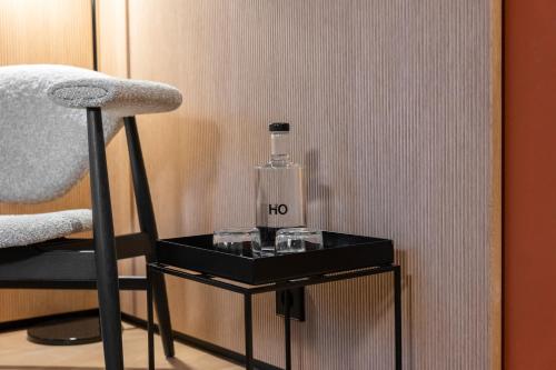 un tavolo nero con una bottiglia sopra accanto a una sedia di HOtello Lehel a Monaco