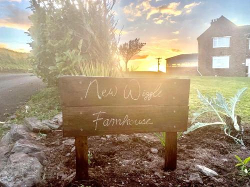 a sign that says new world farmhouse in front of a house at New Wiggle Farmhouse in Millbrook