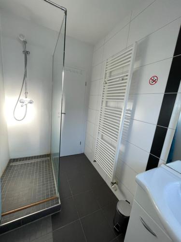 une douche avec une porte vitrée dans une salle de bain dans l'établissement Schöne zentrale Zimmer in Wilhelmshaven, à Wilhelmshaven