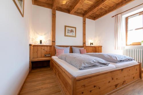 ein Schlafzimmer mit einem großen Holzbett in einem Zimmer in der Unterkunft Streidlhof in Lenggries