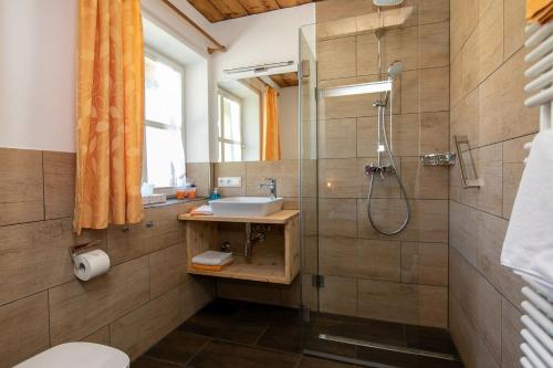 ein Bad mit einem Waschbecken und einer Dusche in der Unterkunft Streidlhof in Lenggries