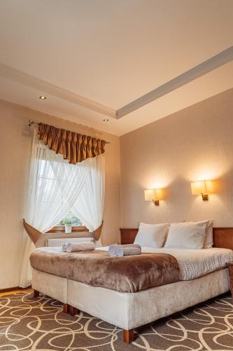 a bedroom with a large bed with a window at Hotel Dwór Choiny in Kazimierzówka