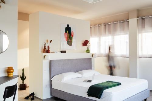 um quarto com uma cama branca e uma toalha verde em MAR Modena Accommodation in Residence em Formigine