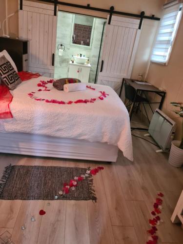 a bedroom with a bed with red roses on the floor at Country Cabin in Midrand