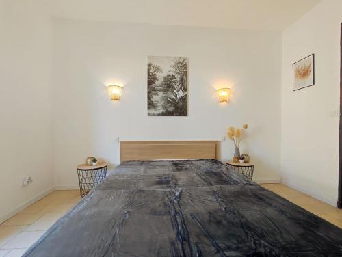 Cette chambre comprend un grand lit et 2 tables. dans l'établissement Appartement avec jardin privatif à 300m de la plage *2*, à Canet