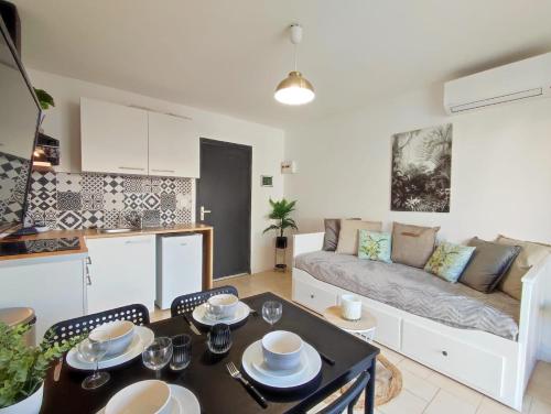 un salon avec un canapé et une table dans l'établissement Appartement avec jardin privatif à 300m de la plage *2*, à Canet