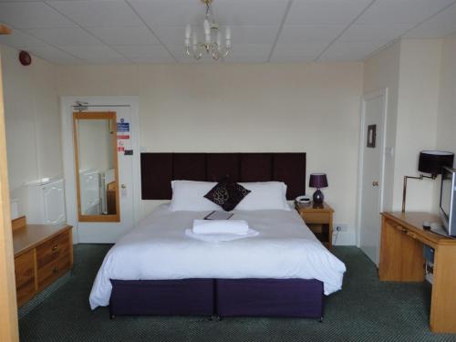 a bedroom with a large bed and a television at Albert & Victoria Hotel in Southport