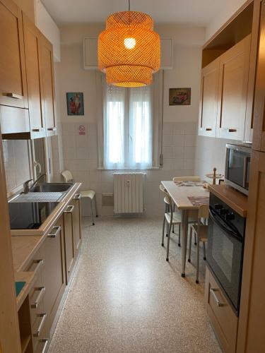 a kitchen with a table and a chandelier at Casa Manolo Cesano Suite Apartment Milan in Cesano Boscone