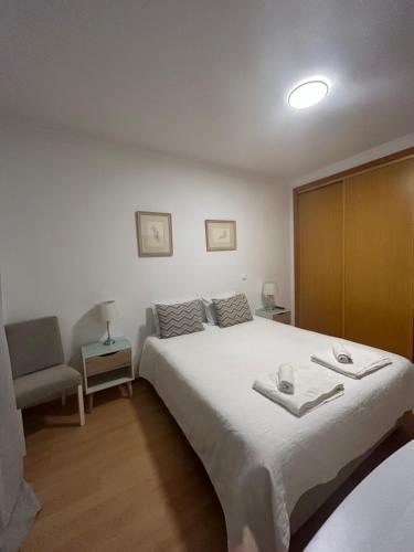 1 dormitorio con 1 cama blanca grande y 1 silla en Lagos Royal Rooms and Suites, en Lagos