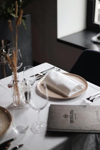 a table with a white table cloth with glasses and a purse at Hotel Mona Plaza in Belgrade