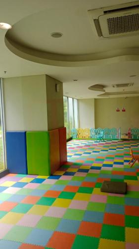 une chambre vide avec des sols et des chaises colorés dans l'établissement Iproperti, à Jakarta