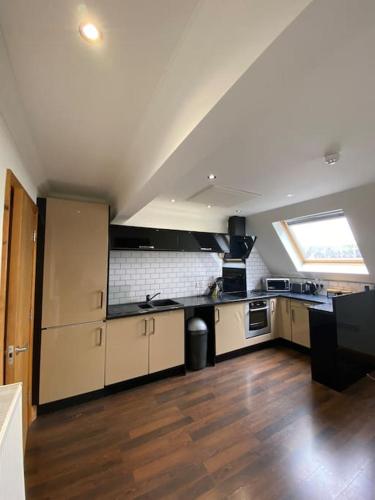 spacious 2 bed apartment in Norwich city centre في نورويتش: مطبخ كبير مع أرضيات خشبية ونافذة