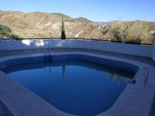 a large swimming pool in a backyard with a fence at RECONECTA CONTIGO MISMO in Carataunas
