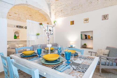 a dining room with a table with blue chairs at Vico di Ostuni Apartments by Rentbeat in Ostuni
