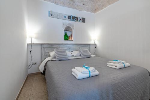 a bedroom with a bed with two towels on it at Vico di Ostuni Apartments by Rentbeat in Ostuni