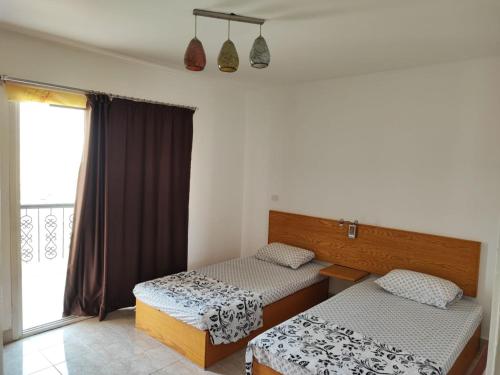 1 dormitorio con 2 camas y ventana en Al Rehab City, Avenue Mall , New Cairo, en New cairo